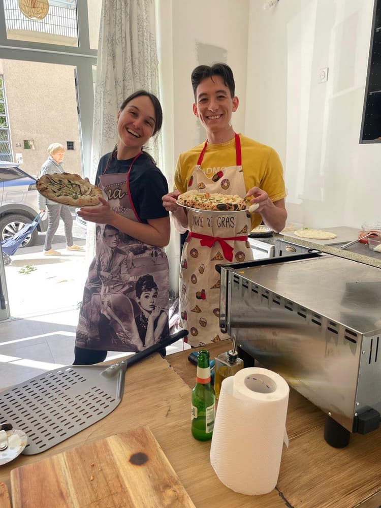 Bénévoles du Café d'Oc présentant des pizzas faites maison